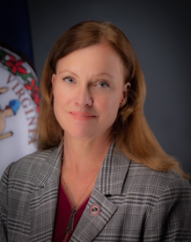 Headshot of Deputy Secretary Leah Mills with the Commonwealth Seal in the background